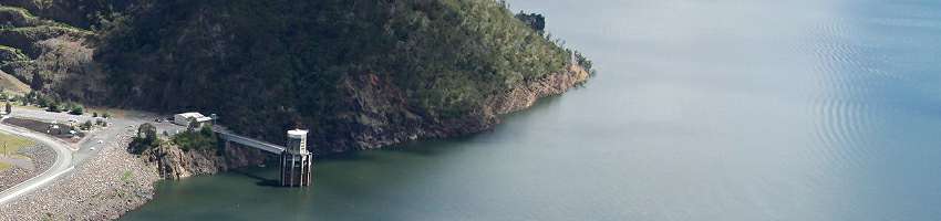 Image of a water storage full of water with the banks and infrastructure in the foreground